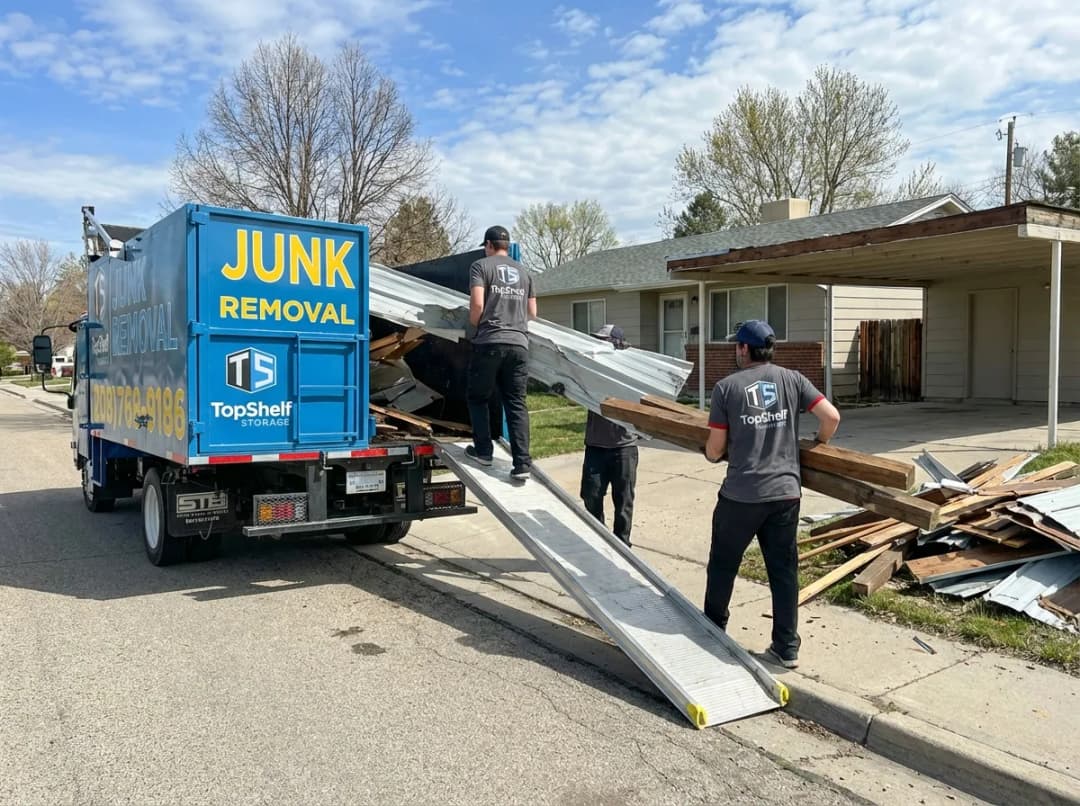 Top Shelf crew member using tools to dismantle an old carport in Eagle Idaho