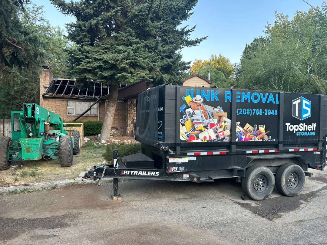 Top Shelf trailer and heavy equipment at a house demolition site