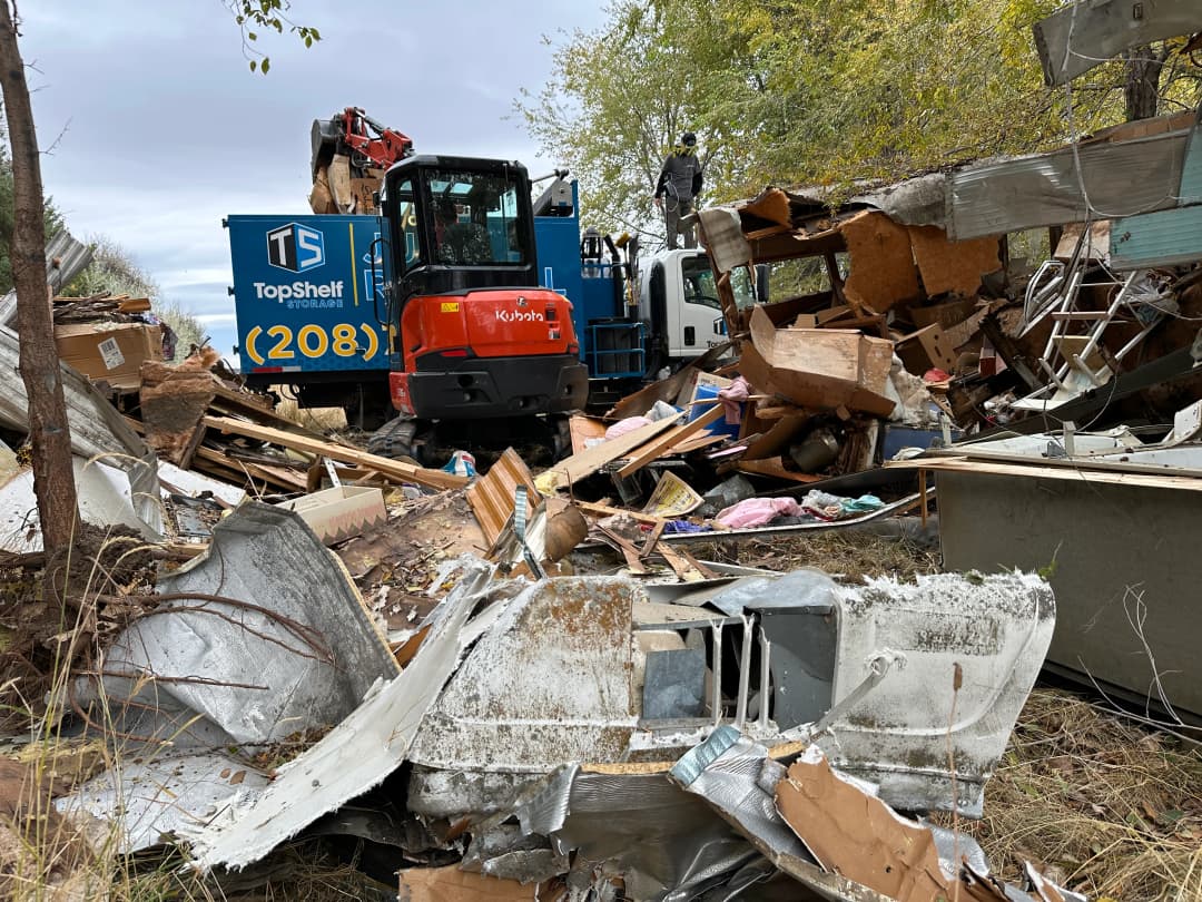 Top Shelf Kubota excavator clearing demolition debris and overgrown vegetation during a land clearing project in Boise Idaho