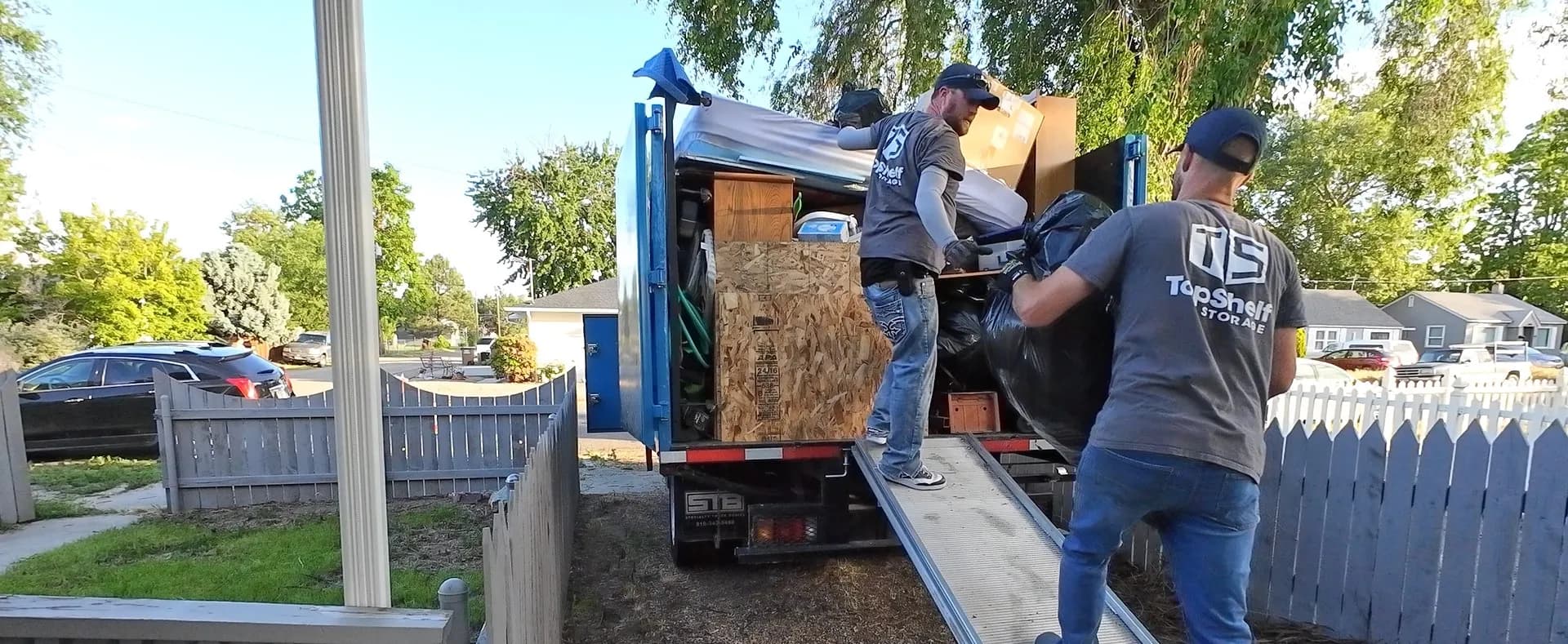 Two Top Shelf crew members loading household items up the truck ramp during a house cleanout in Norterra, Star, Idaho