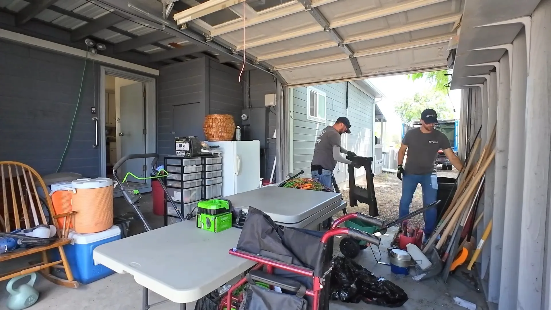Two Top Shelf crew members sorting through household items during a garage cleanout in Downtown Emmett, Idaho