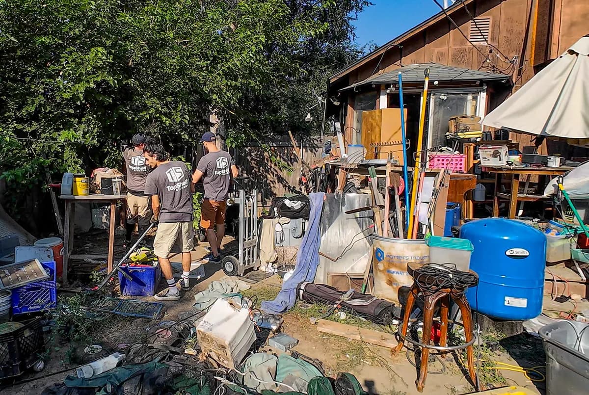 Top Shelf crew sorting through accumulated items in a cluttered backyard during a hoarding cleanup in Boise Idaho