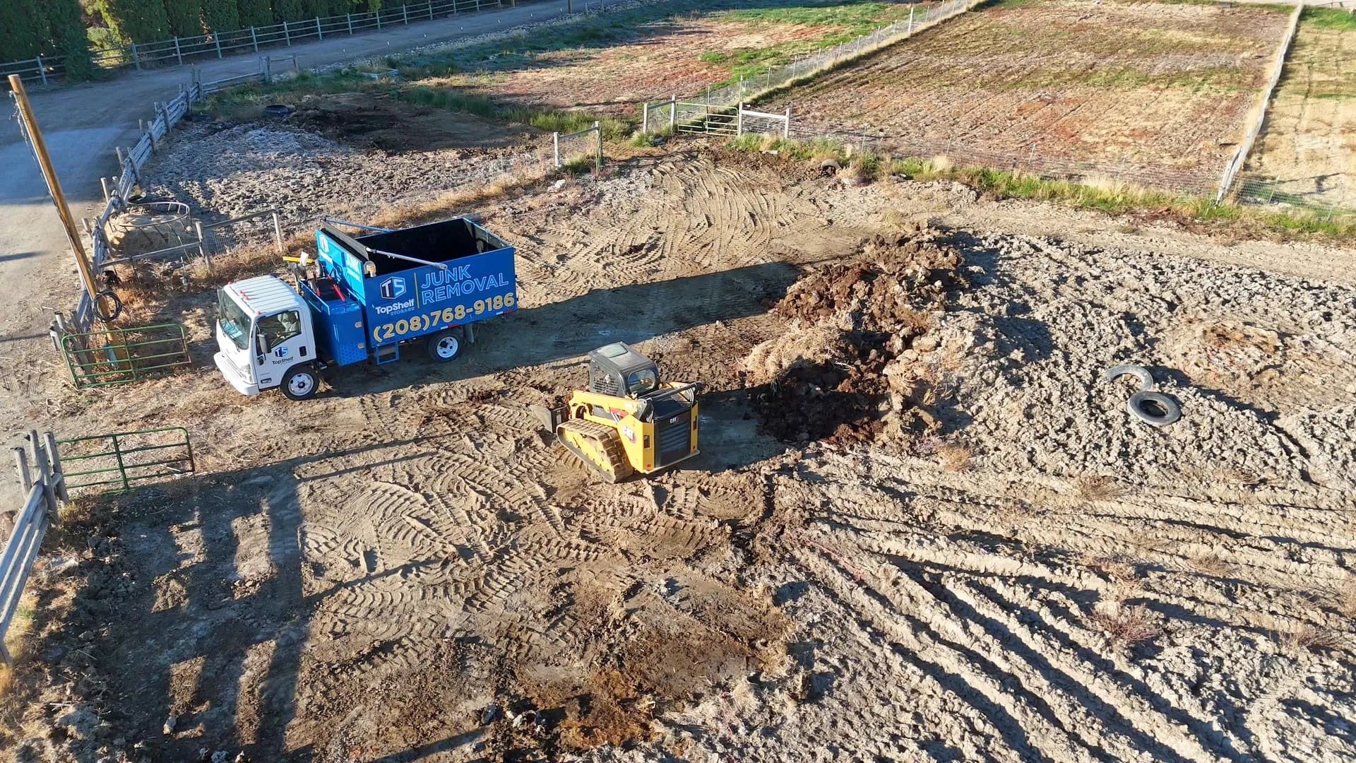 Aerial view of Top Shelf junk removal truck and skid steer clearing manure from a horse property in Eagle Hills, Eagle, Idaho