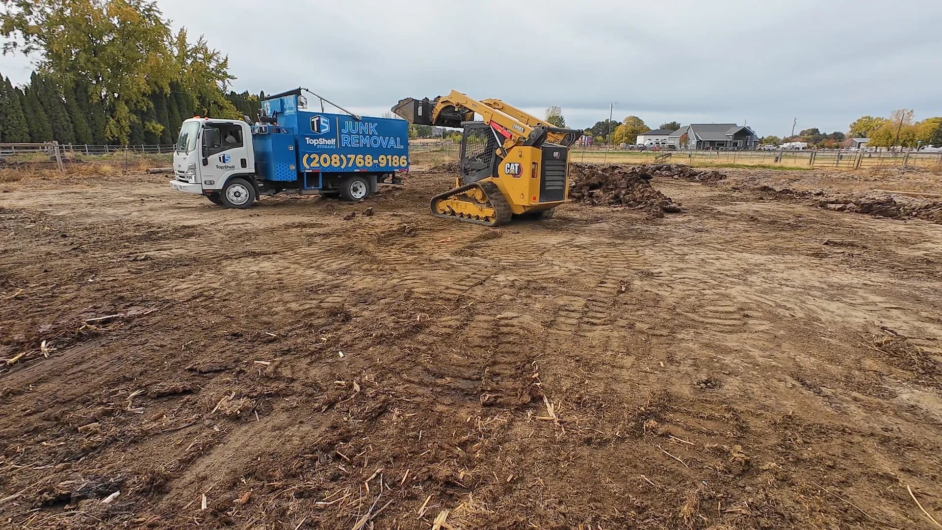Top Shelf branded truck and CAT skid steer loading manure on a ranch property in Dry Creek Ranch, Eagle, Idaho