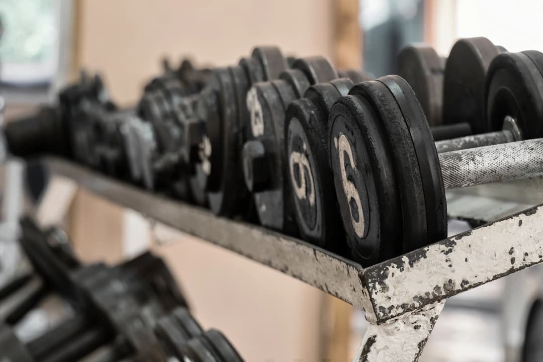 Dumbbell rack being removed by Top Shelf crew during a gym equipment cleanout