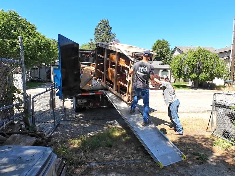 Top Shelf junk removal crew hauling dismantled hot tub debris onto the truck in Southeast Boise, Idaho
