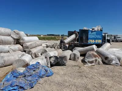Top Shelf crew unloading commercial carpet rolls at disposal site in Caldwell Idaho