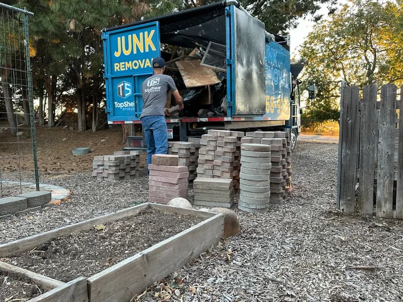 Top Shelf junk removal crew loading stacked pavers into the truck in Lone Star, Nampa, Idaho