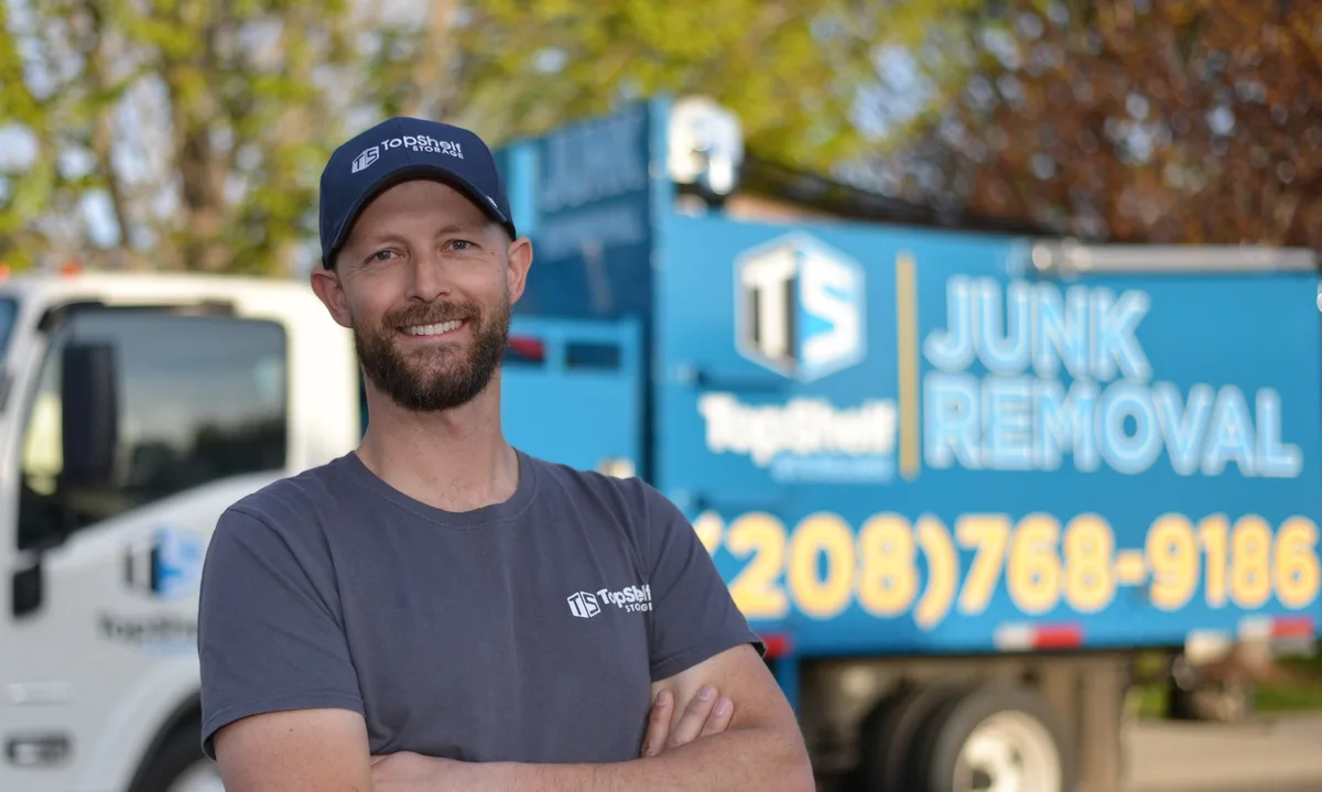 Eric Hinderager, owner of Top Shelf Junk Removal & Demolition, standing in front of branded junk removal truck in Boise Idaho