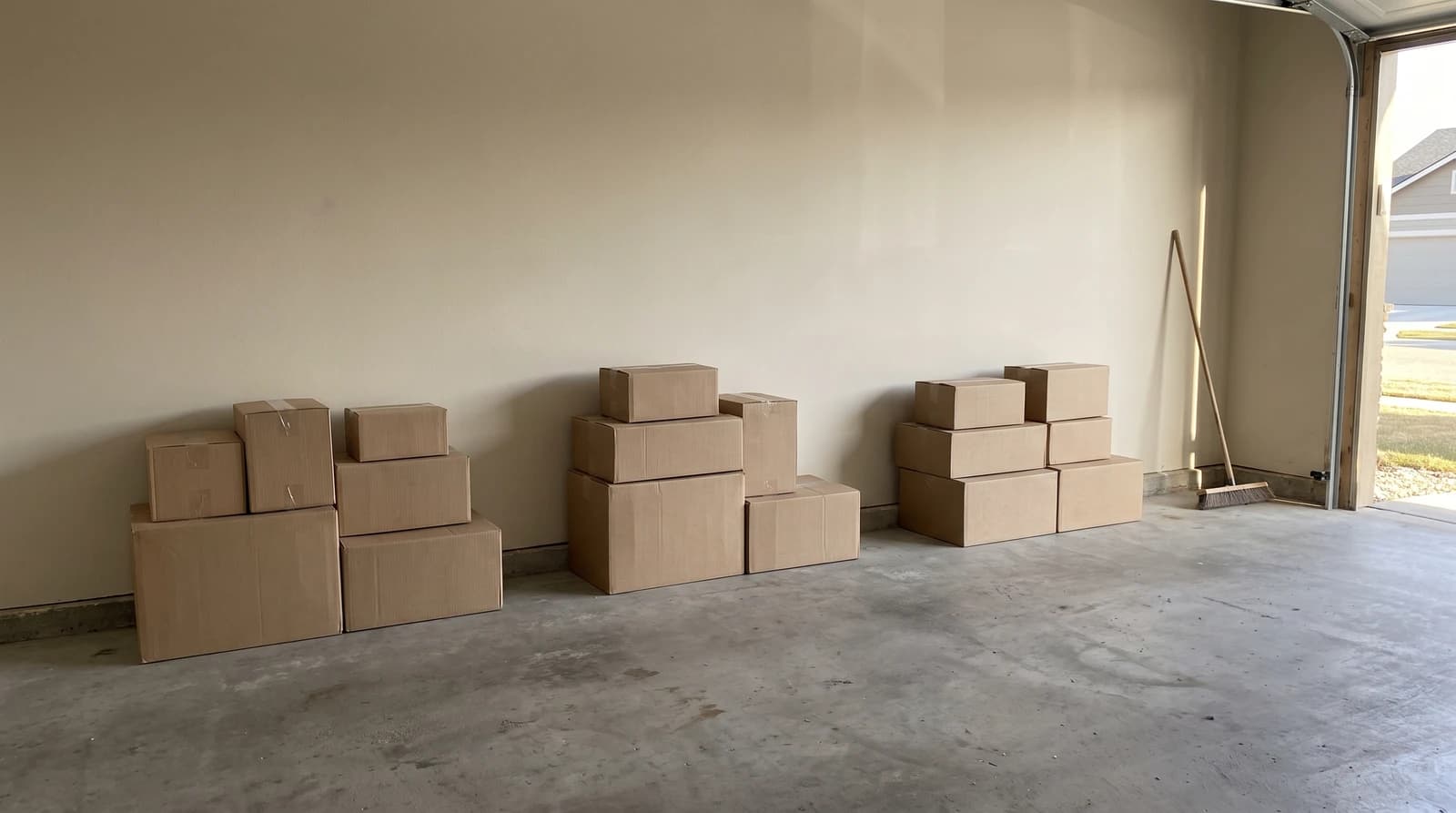 Sorted stacks of plain cardboard boxes on a cleared garage floor during a garage cleanout in Star, Idaho