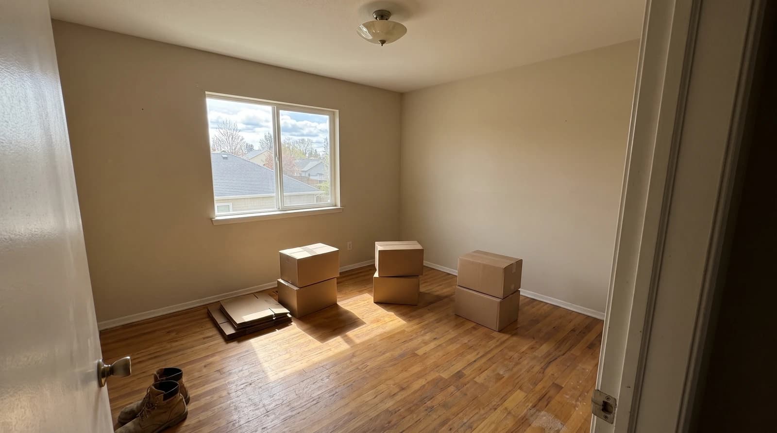 Sorted cardboard boxes grouped on the bare floor of a cleared bedroom during a hoarding cleanup in Nampa, Idaho
