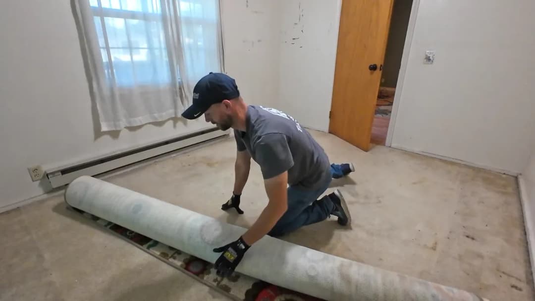 Top Shelf crew rolling up carpet during a demolition project