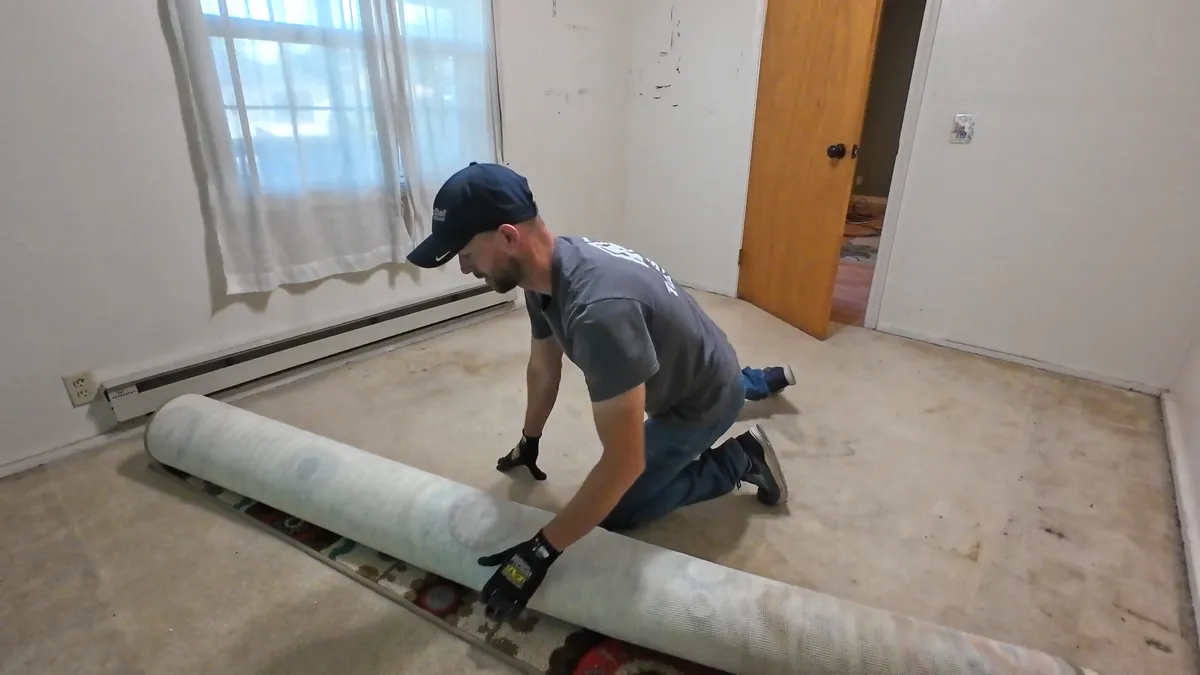 Top Shelf crew rolling up carpet during a demolition project