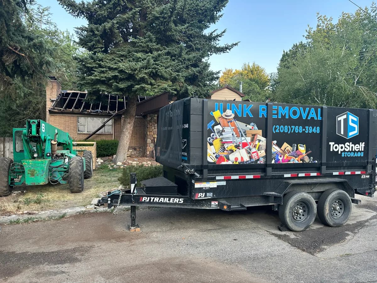 Top Shelf trailer and heavy equipment at a house demolition site