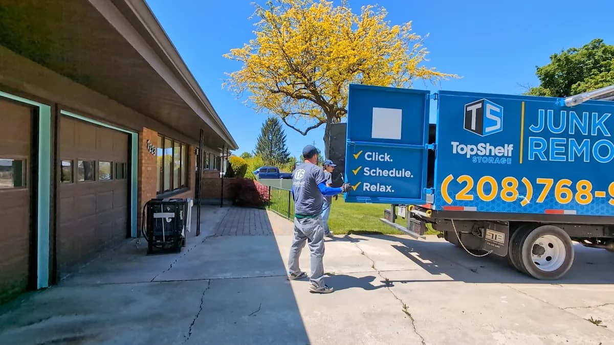 Top Shelf crew loading a dishwasher onto the branded truck in a driveway in Meridian Idaho