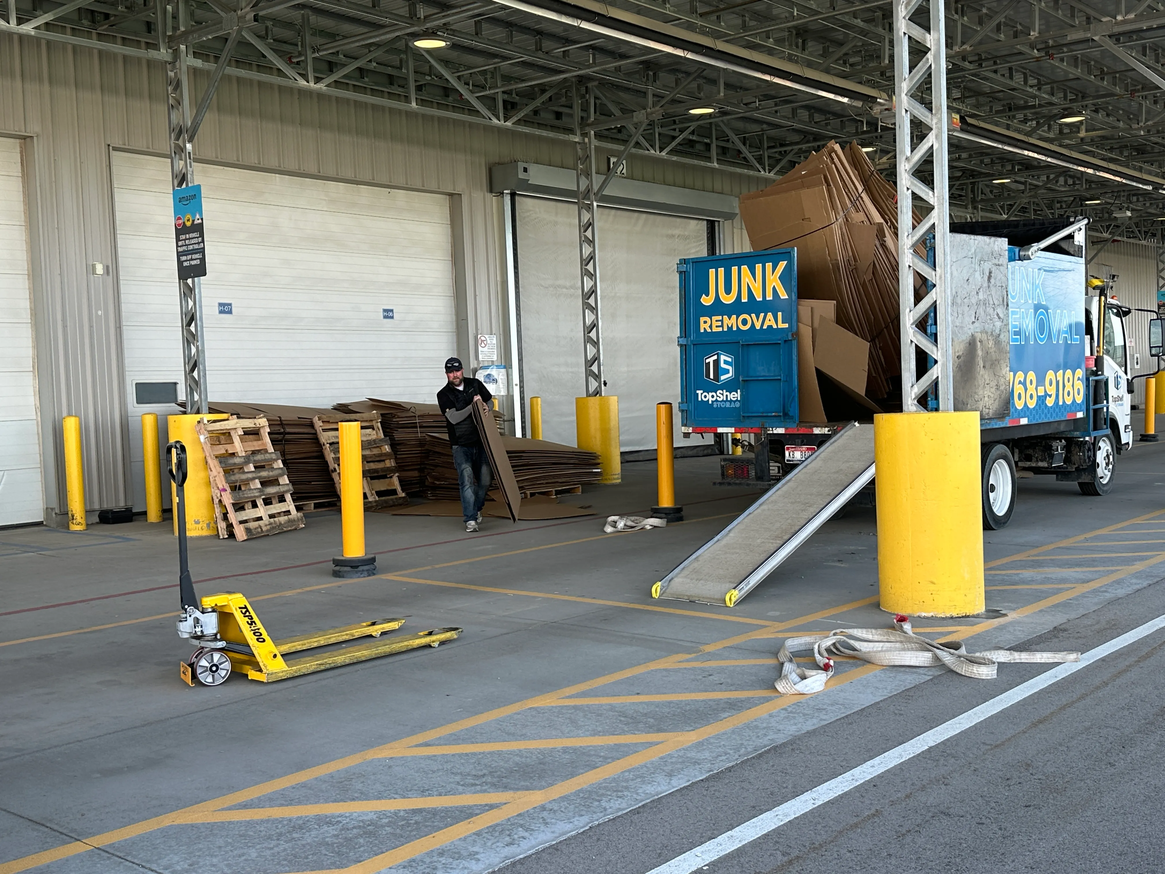 Top Shelf crew hauling flattened cardboard from a distribution center loading dock to the branded truck in Garden City Idaho