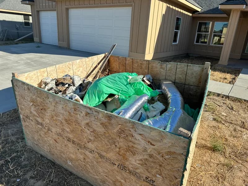 Dumpster loaded with plywood and insulation debris during construction cleanup in Star Idaho