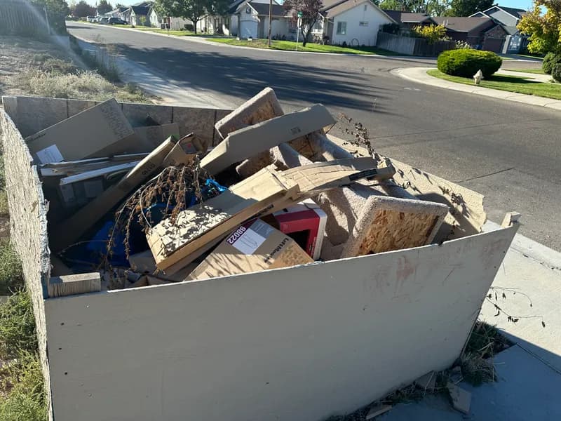 Overflowing dumpster with plywood and construction debris in Kuna Idaho