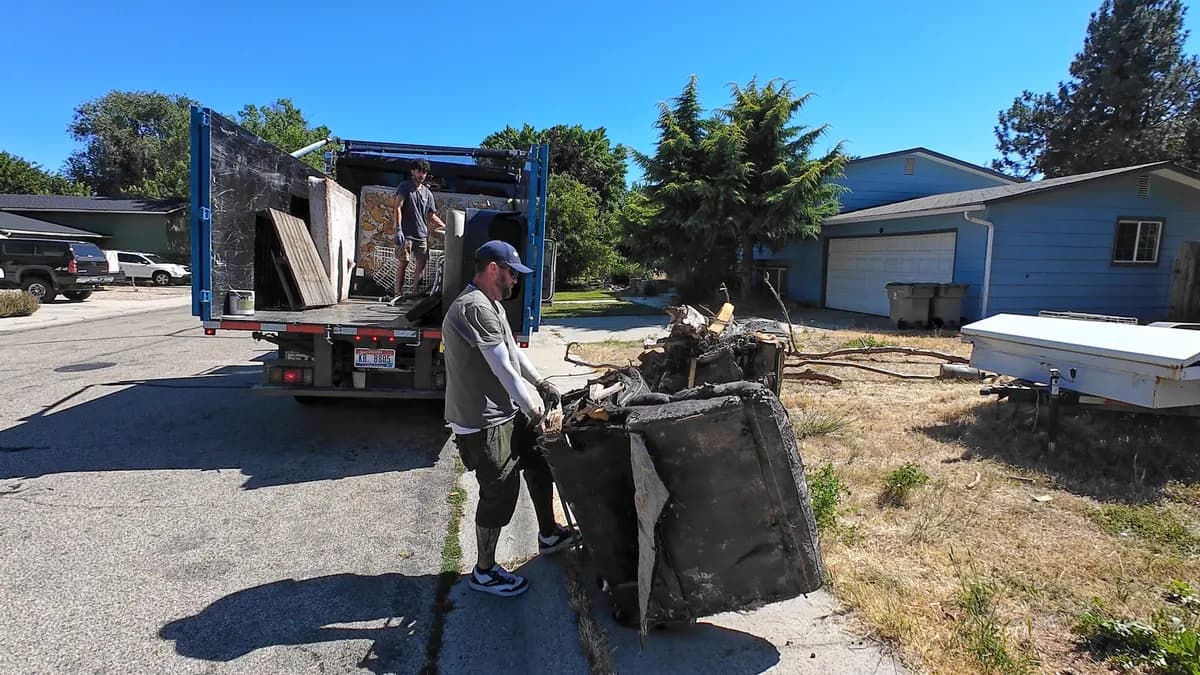 Top Shelf crew loading a couch curbside into the junk removal truck in Eagle Idaho