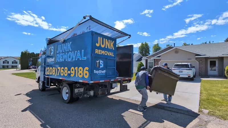Top Shelf crew picking up a couch beside the branded truck in a Treasure Valley neighborhood