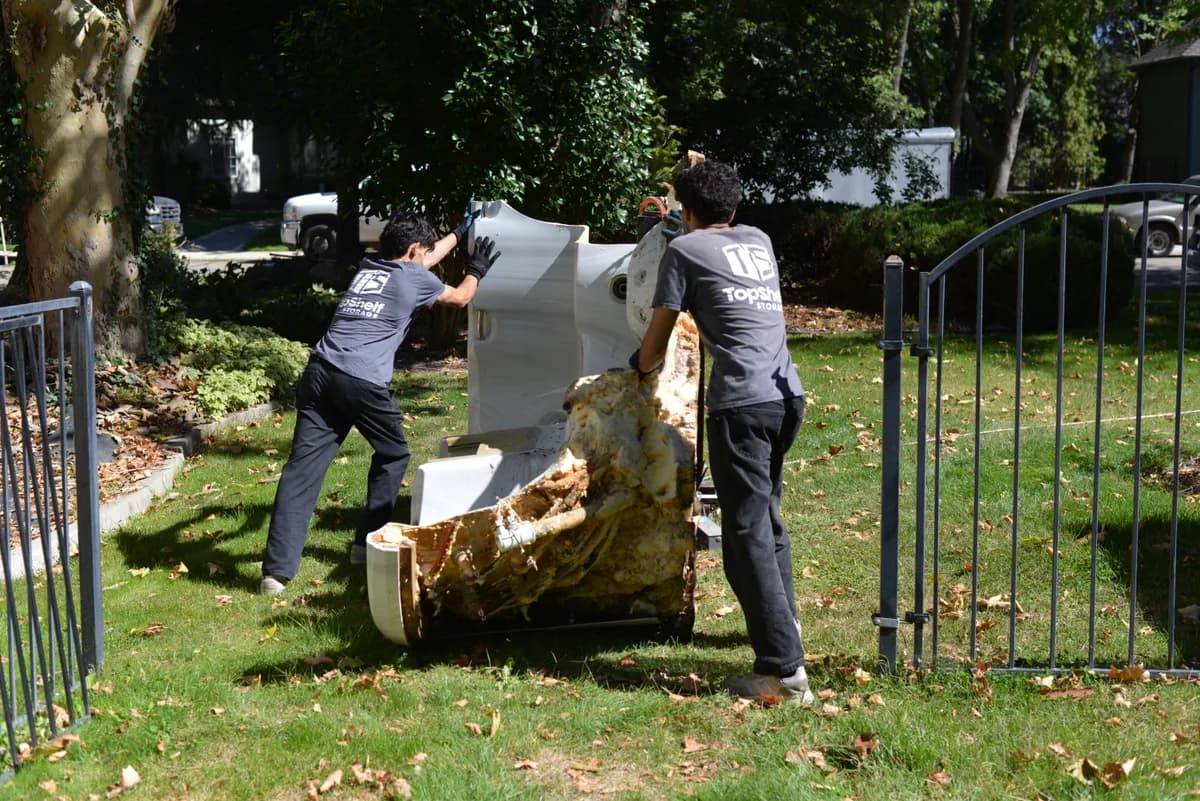 Top Shelf crew carrying a heavy hot tub during a removal job in Eagle Idaho
