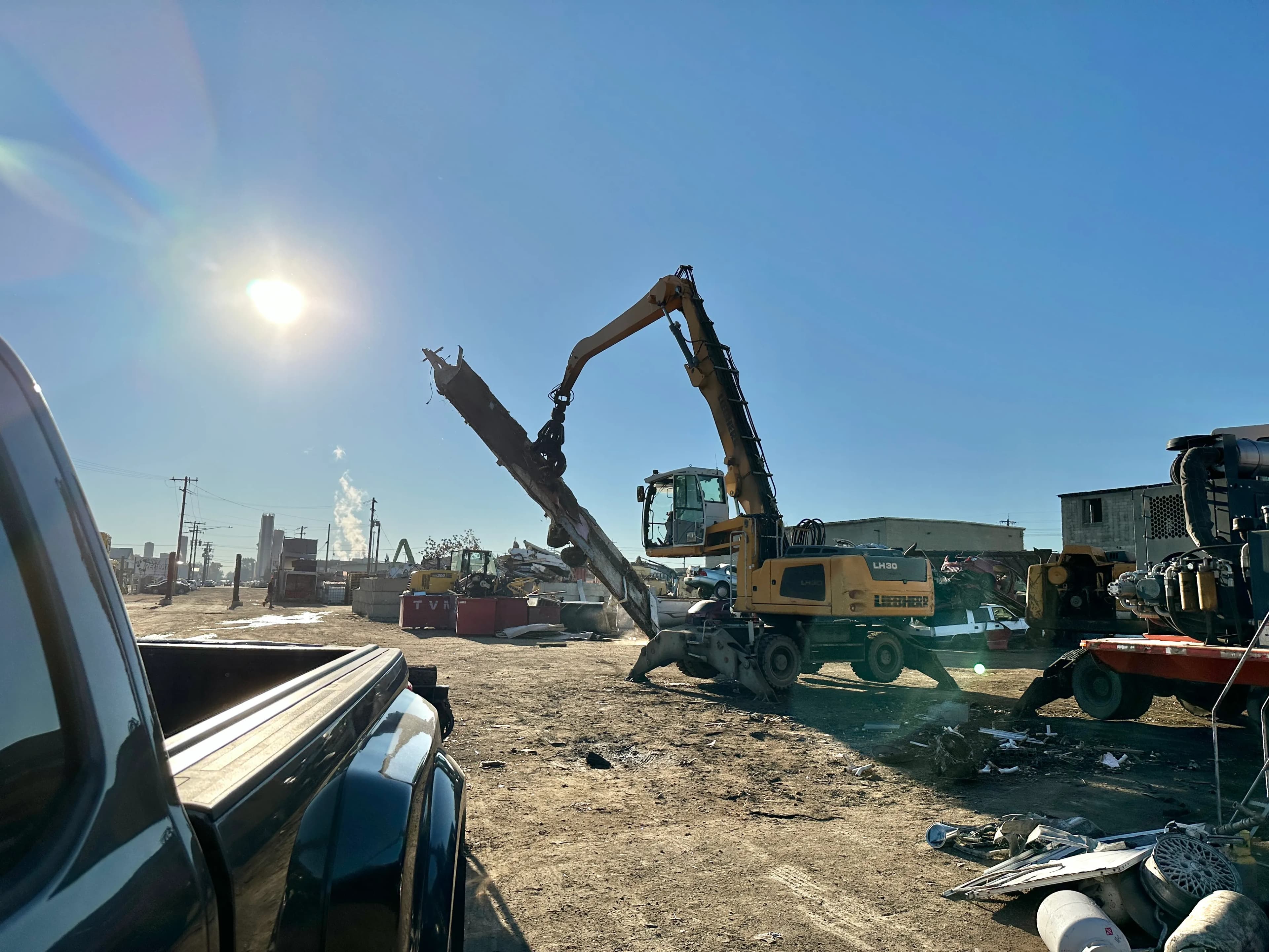 Material handler lifting a large piece of scrap metal at a recycling yard after a Top Shelf scrap metal removal job in Star Idaho