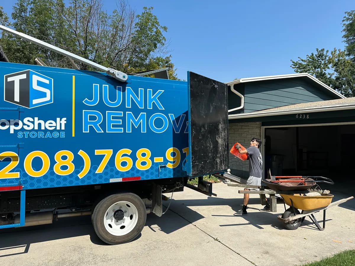 Top Shelf crew loading household junk into the branded truck from a driveway in Boise Idaho