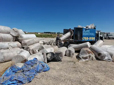 Top Shelf crew unloading commercial carpet rolls at disposal site in Caldwell Idaho