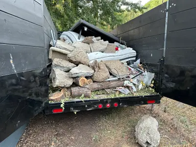Truck loaded with concrete rocks and logs for heavy item removal in Eagle Idaho